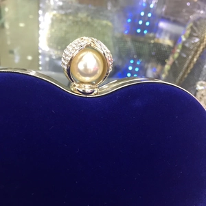 Détail de la pochette en velours bleu roi avec grande perle et fermoir en strass