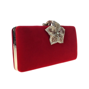 Détail d'une pochette de soirée en velours rouge avec fermoir fleur orné de cristaux