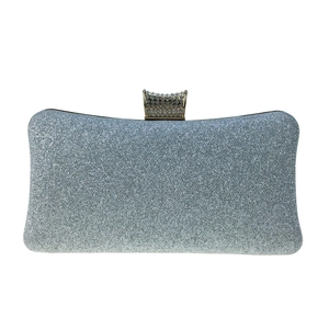 Close-up of silver sequined evening clutch bag with sparkling rhinestone encrusted gold clasp