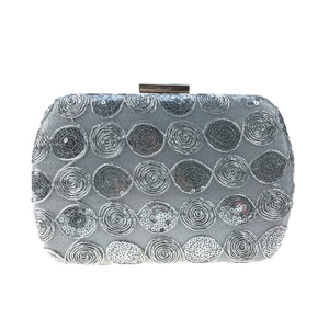 Macro shot of silver sequins and spiral metallic embroidery on an evening clutch bag