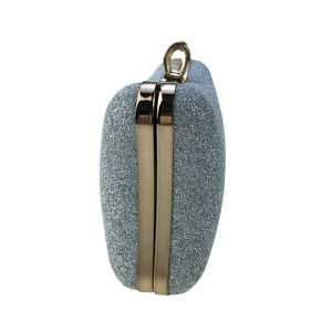 Detail of silver glitter evening clutch with gold metal frame and ring clasp