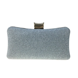 Detail of silver sequin evening clutch bag showing glitter texture and metal clasp closure