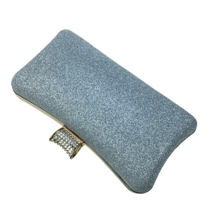 Detailed close-up of light blue glitter clutch with gold rhinestone encrusted clasp