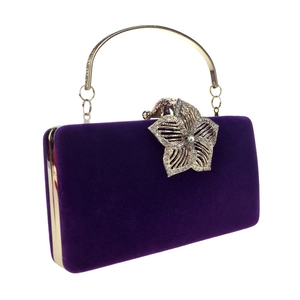 Détail d'une pochette de soirée en velours violet avec fermoir fleur dorée et strass