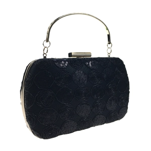 Detail of black sequin clutch bag with circular pattern and gold round metal handle