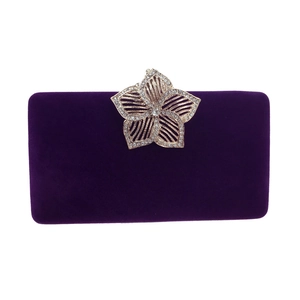 Détail d'une pochette de soirée en velours violet avec fermoir fleur orné de strass brillants