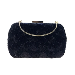 Detailed view of black sequined lace evening clutch with 3D rose embroidery and gold handle