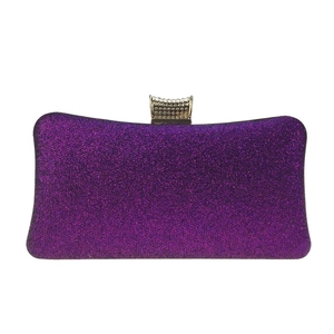 Close-up of sparkling purple glitter evening clutch with elegant gold metal clasp detail