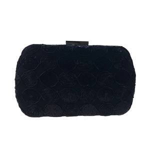 Detail of black sequin evening clutch featuring intricate rose floral patterns and metal clasp