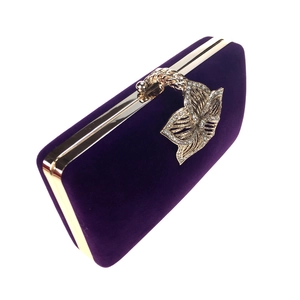 Détail d'une pochette de soirée en velours avec un fermoir papillon serti de diamants