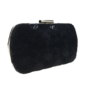 Detail of black evening clutch bag with sequined rose patterns and silver metal clasp
