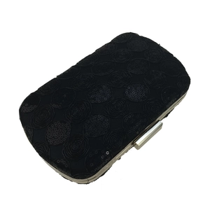 Close-up of black sequined evening clutch with rose patterns and metal clasp