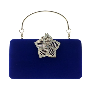 Détail de la pochette en velours bleu roi avec fermoir fleur et anneau doré