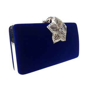 Détail de la pochette de soirée en velours bleu avec fermoir floral doré et strass