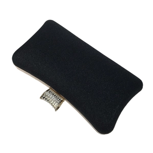 Close-up of black evening clutch bag with gold trim and rhinestone-studded clasp