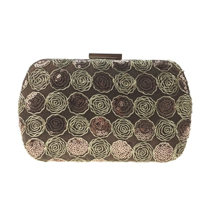 Close-up of golden sequins and lace rose embroidery on a luxury evening clutch bag