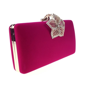Détail d'une pochette de soirée en velours rose avec cadre doré et fermoir fleur en diamant