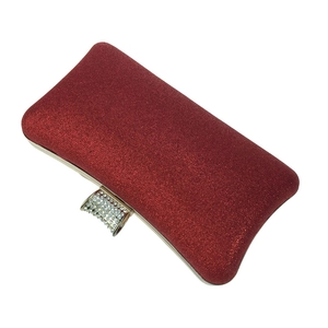 Macro detail of red sequin fabric texture with a crystal encrusted gold clasp evening bag