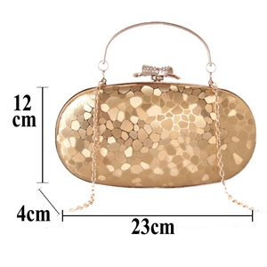 Detailed view of golden evening clutch bag with size 23x12x4cm and crystal bow clasp