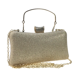 Macro shot of gold sequin clutch bag with crystal buckle and detachable chain strap