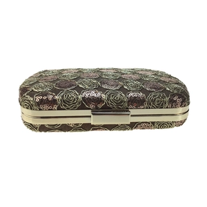 Detail of evening clutch featuring bronze sequins with rose pattern and gold metal frame