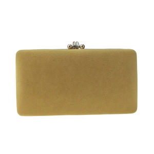 Détail macro de la pochette en velours jaune moutarde avec fermoir fleuri en strass