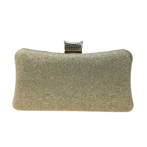 Close-up of gold sequin evening clutch bag showing metallic texture and snap closure