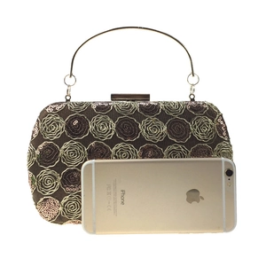 Detail of sequin rose clutch bag with metal handle and phone for size reference