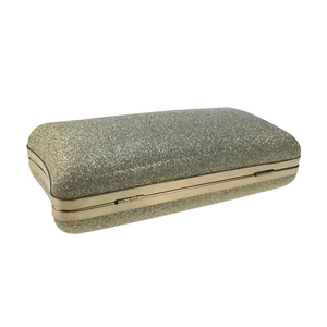 Close-up of champagne gold glitter evening clutch bag with metal frame and shimmer texture