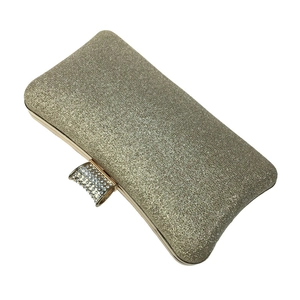 Detail of champagne gold glitter clutch with sparkling rhinestone cylindrical clasp