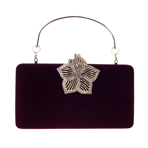 Détail du fermoir fleur en cristal argenté sur la pochette de soirée en velours bordeaux