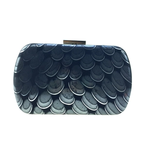 Detail of evening clutch bag featuring gradient peacock feather pattern and metal clasp