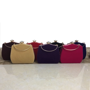 Macro shot of colorful velvet evening clutch bags with sparkling diamond clasps and handles