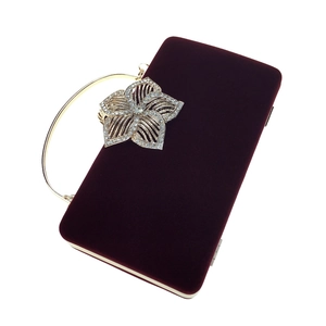 Détails d'une pochette de soirée en velours avec fermoir fleur strass et anse dorée