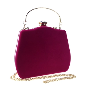 Close-up of magenta velvet evening bag with gold handle, jewel clasp and chain strap