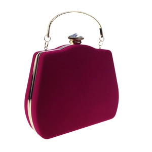 Detail view of fuchsia velvet clutch bag with gold frame and diamond-shaped crystal clasp