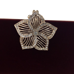 Détail de la boucle fleurie en cristal sur pochette de soirée en velours bordeaux