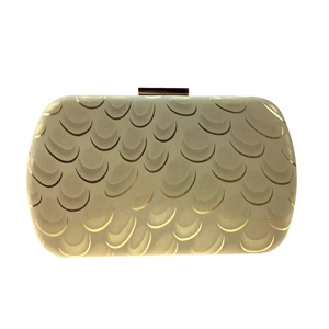 Detail view of the cream evening clutch with golden peacock scales and metal clasp