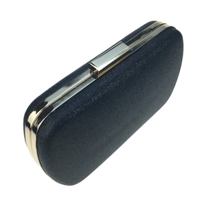 Macro detail of navy glitter evening clutch featuring elegant gold metal frame and clasp
