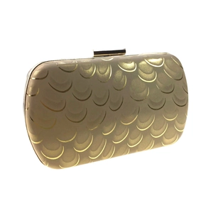 Close-up of champagne gold hard shell evening bag with metallic peacock scale pattern