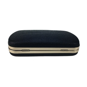 Detail view of the navy blue velvet evening clutch with elegant gold metal frame and hinge