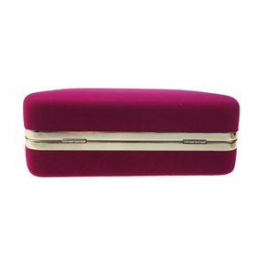 Detailed view of magenta velvet evening clutch with gold metal frame and secure hinge