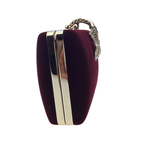 Détail de pochette de soirée en velours bordeaux avec cadre doré et fermoir fleur en strass