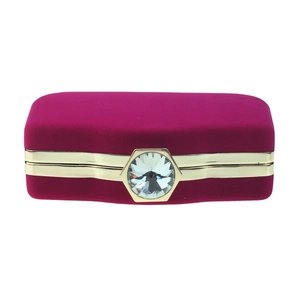 Detail of velvet evening clutch featuring a large hexagonal crystal and gold metallic trim