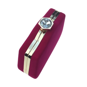 Detail view of fuchsia velvet evening clutch featuring gold trim and hexagonal crystal clasp