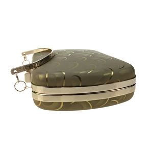 Detail of champagne gold evening clutch featuring textured patterns and metallic handle