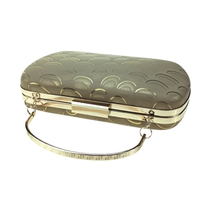 Detail of champagne gold evening bag showing geometric pattern and metallic frame