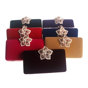 Détail de pochettes de soirée en velours coloré avec fermoir fleur orné de cristaux