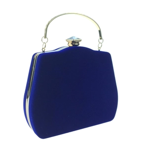 Detail of royal blue velvet evening clutch featuring a golden frame and crystal clasp
