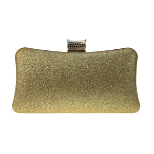 Detailed view of luxury gold glitter surface and vintage metal clasp on evening clutch bag